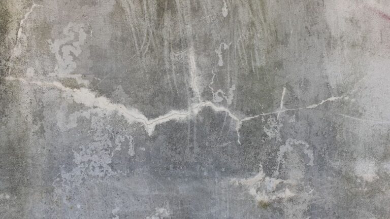 Weathered concrete wall with visible cracks and staining across the surface.